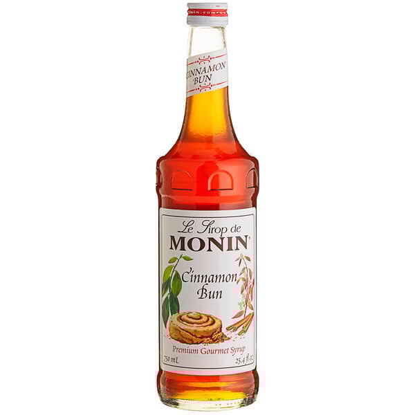 A bottle of Monin Cinnamon Bun flavoring syrup with a white label.