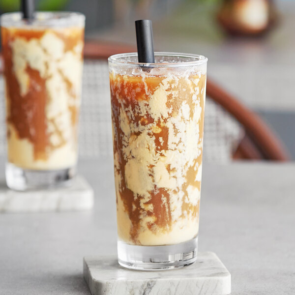 Two glasses of brown Bossen Plain Tiger bubble tea with straws on a marble surface.