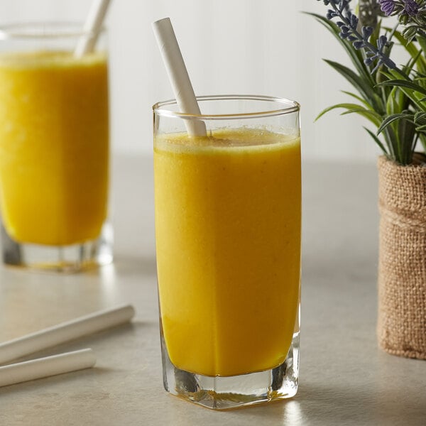 A glass of yellow liquid made with Monin Golden Turmeric Flavoring Syrup with a straw.