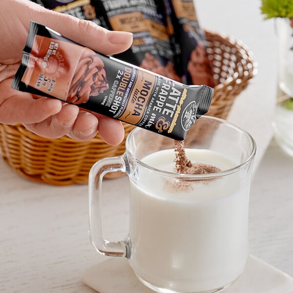 A hand pouring Frozen Bean Double Shot Mocha Latte Blended Iced Coffee into a glass.
