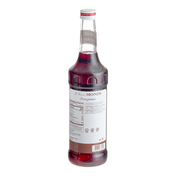 A bottle of Monin pomegranate syrup with a white label.