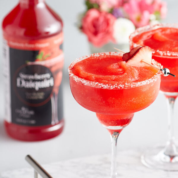 A red strawberry daiquiri made with Regal cocktail puree in a glass on a marble counter.