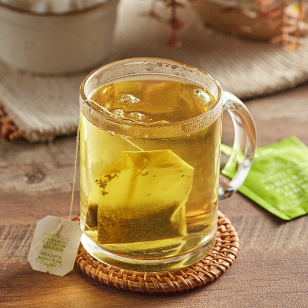 A glass mug of Harney & Sons Citron Green Tea with a tea bag inside.