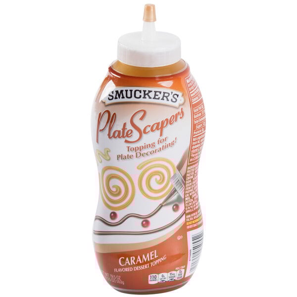 A plastic Smucker's bottle of spiced caramel syrup with a white label.