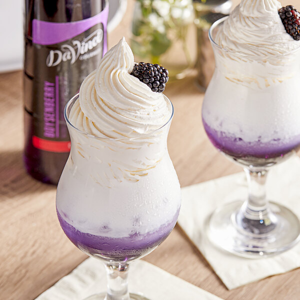 Two glasses with ice cream, blackberries, and DaVinci Boysenberry syrup on top.