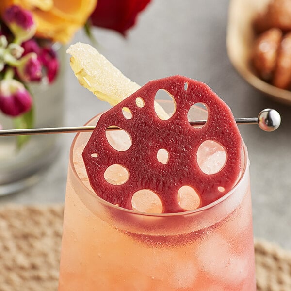 A cocktail with a Wild Hibiscus Lotus Root in Hibiscus and Ginger Syrup on the rim.