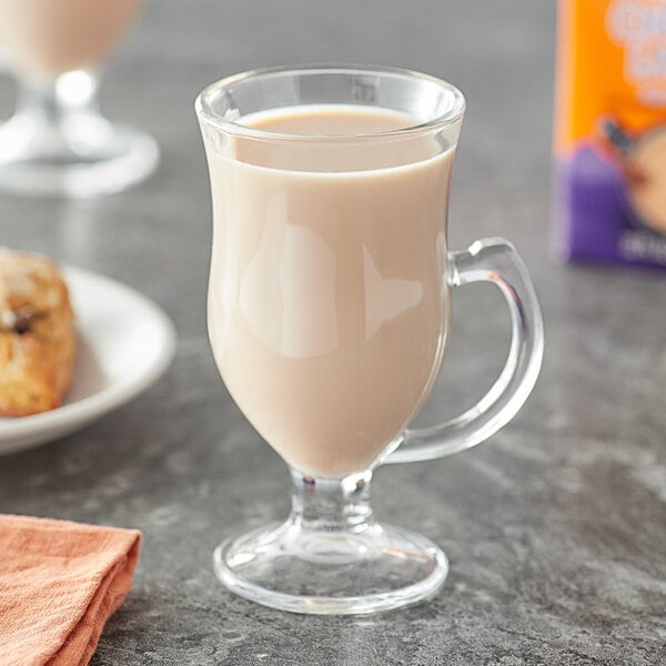 A glass cup of Oregon Chai Sugar Free Original Chai Tea Latte on a table.