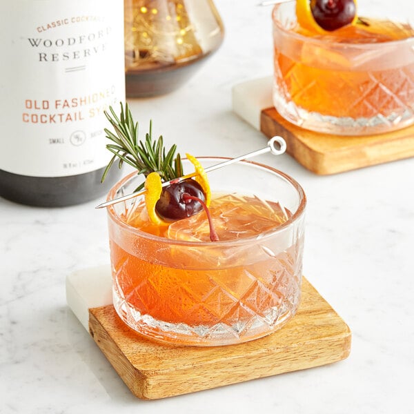 Two glasses of Woodford Reserve Old Fashioned Syrup with cherries and orange slices.