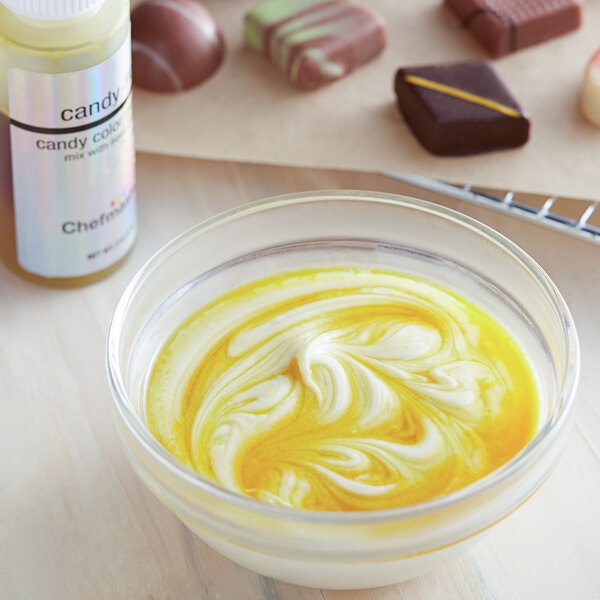A bowl of food with yellow liquid next to chocolates with a white Chefmaster label.