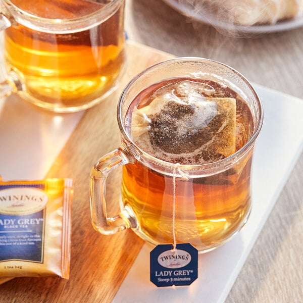 A mug of Twinings Lady Grey tea with a tea bag in it.