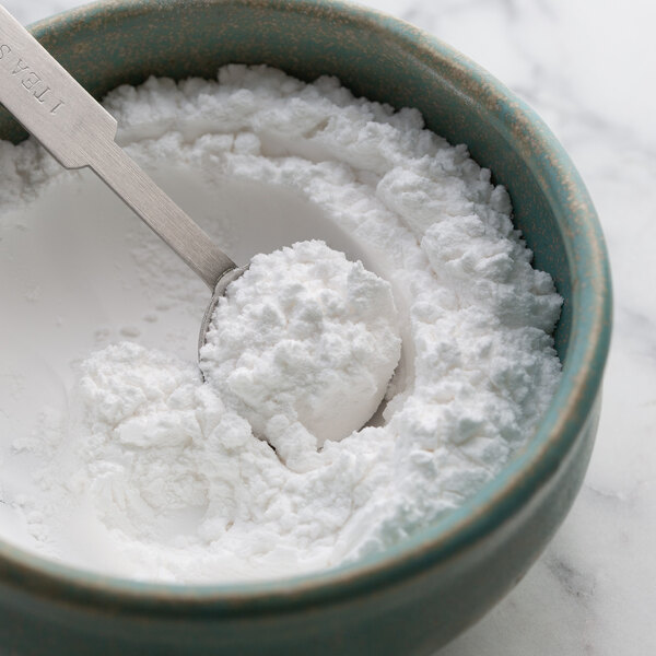 A spoon in a bowl of white powder.