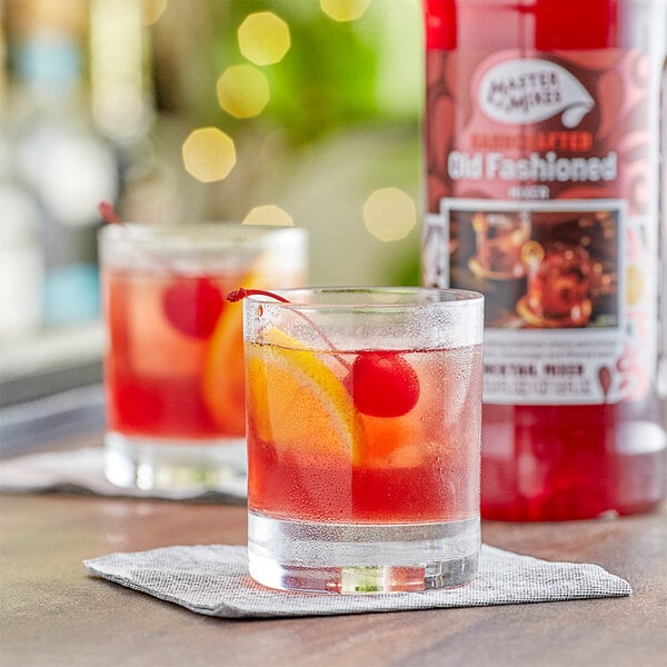 A glass of Master of Mixes Old Fashioned with an orange slice and cherry.