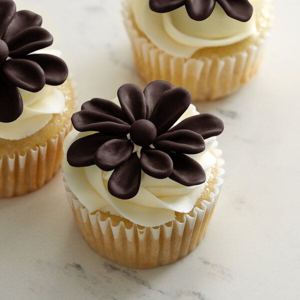 A cupcake with a Satin Ice ChocoPan deep brown chocolate flower on top.