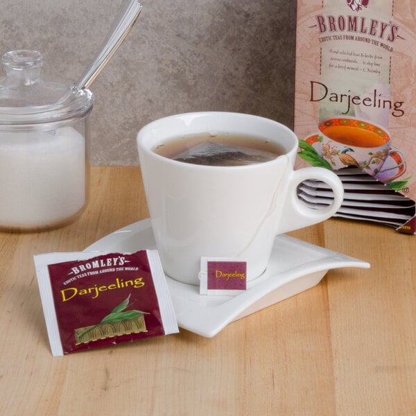 A cup of Bromley Exotic Darjeeling Tea with a tea bag on a saucer.