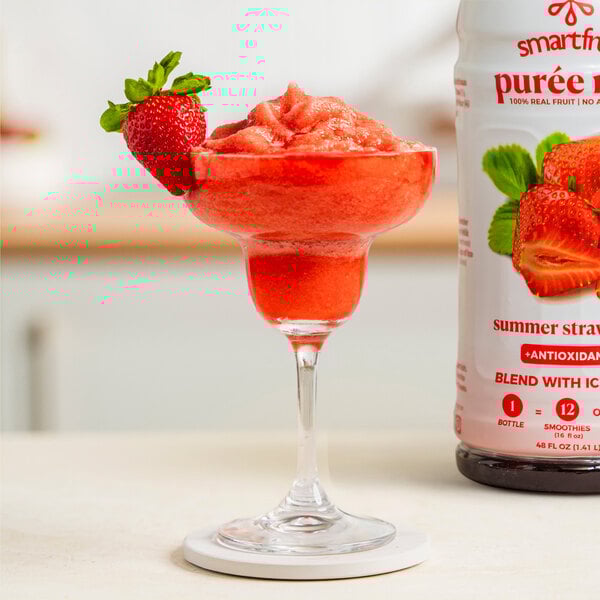 A glass of Smartfruit Summer Strawberry puree with a red strawberry smoothie inside, garnished with a strawberry.