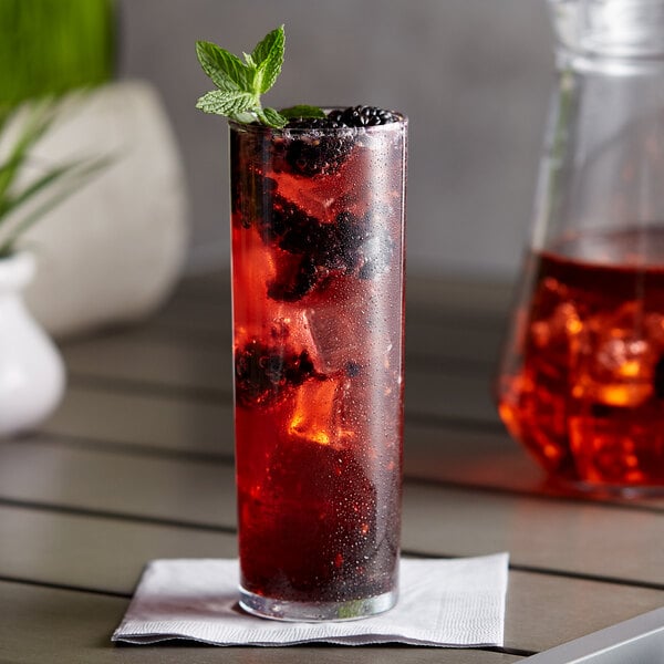 A glass of DaVinci Gourmet Blackberry syrup with ice and berries in it.