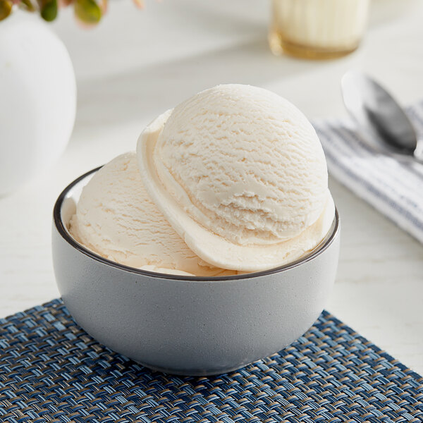 A bowl of I. Rice peach hard serve ice cream with a scoop of ice cream.