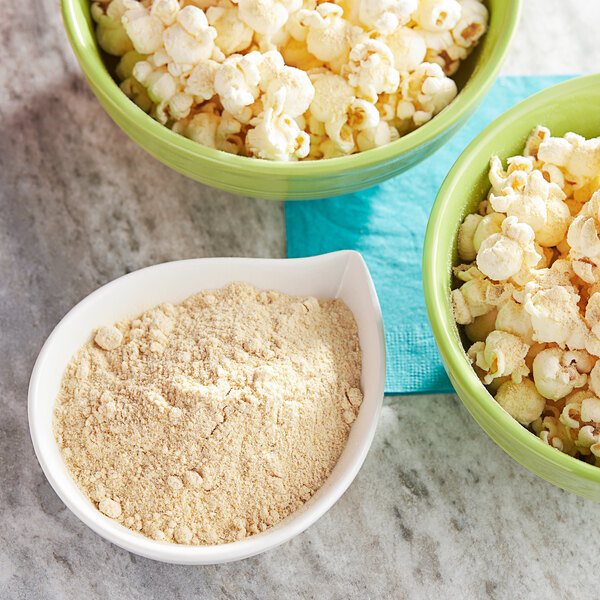 A bowl of popcorn with yellow powdered seasoning.