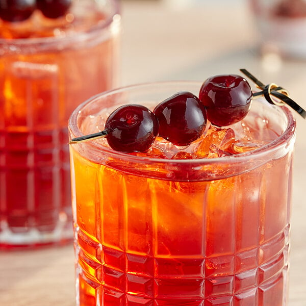 A glass of a red drink with a Toschi Amarena cherry on top.