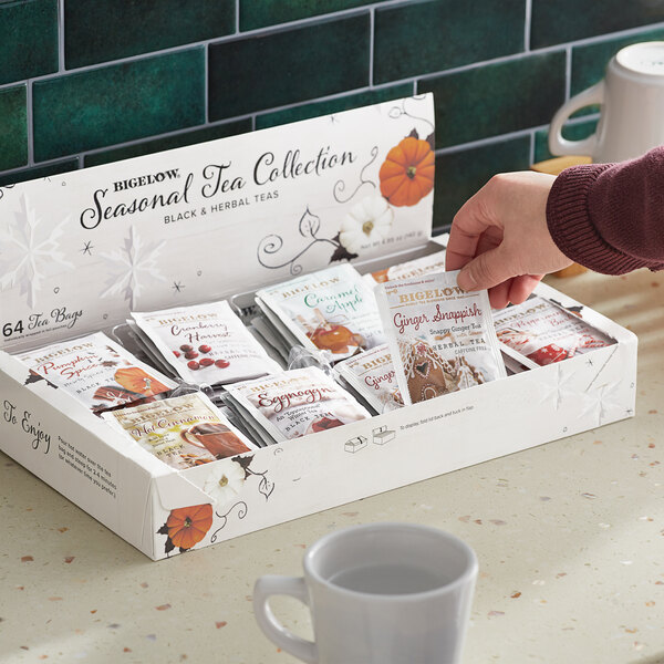 A hand holding a Bigelow Seasonal Tea box