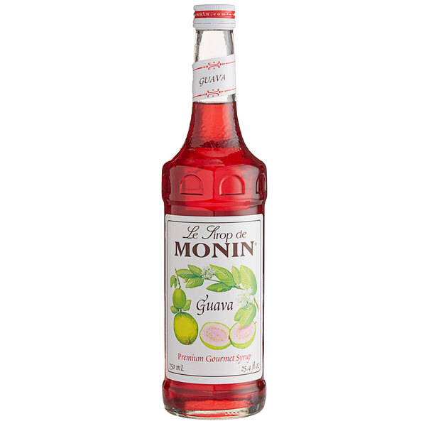 A close up of a Monin Premium Guava Fruit Syrup bottle filled with red liquid.