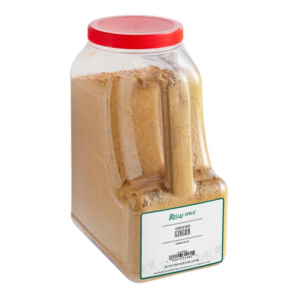 A plastic container of brown Regal Ground Ginger powder with a lid.