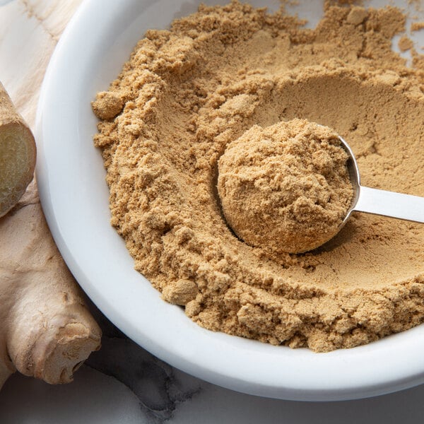 A spoon in a bowl of brown Regal Ground Ginger powder.