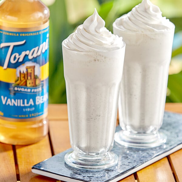 A glass of milkshake with a straw made using Torani Sugar-Free Vanilla Bean Flavoring syrup.