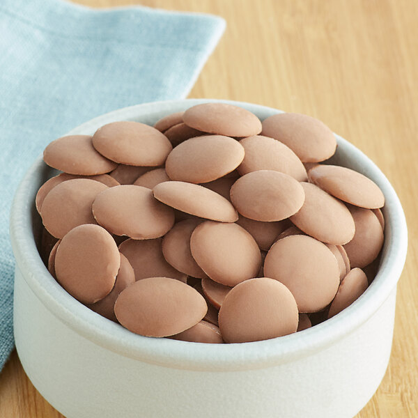 A bowl of Cacao Barry milk chocolate pistoles.