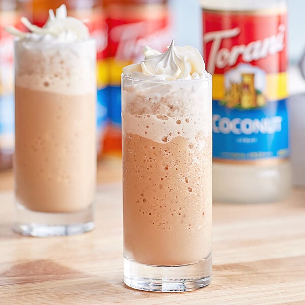 Two glasses of iced coffee with whipped cream and Torani coconut syrup.