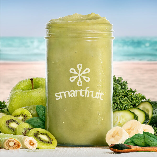 A jar of Smartfruit Harvest Greens smoothie mix with a green smoothie inside.