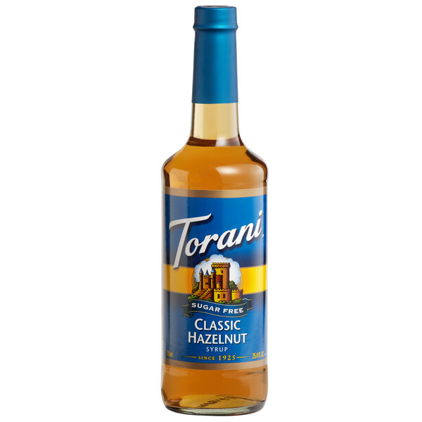 A Torani Sugar-Free Classic Hazelnut flavoring syrup bottle with a blue label filled with brown liquid.
