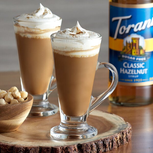 A glass of coffee with Torani Sugar-Free Classic Hazelnut syrup on a table.