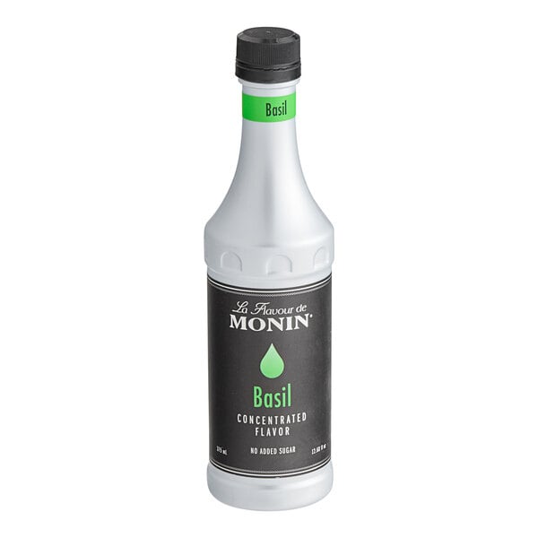 A case of four Monin Basil Concentrated Flavor bottles with black and white labels.
