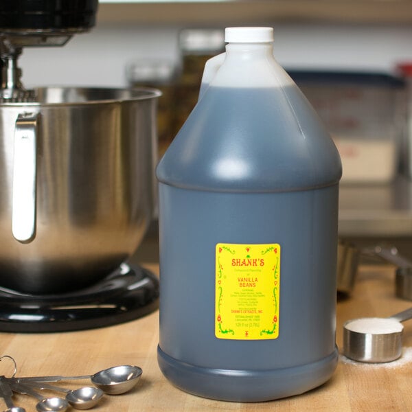 A blue jug of Shank's Imitation Vanilla sitting on a counter next to a mixing bowl.