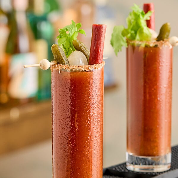 Two glasses of Zing Zang Bloody Mary next to a bottle of Zing Zang Bloody Mary Mix.