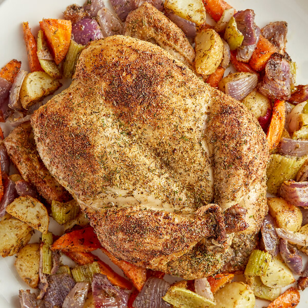 A plate of a whole chicken with vegetables seasoned with Regal Canadian Chicken Seasoning.