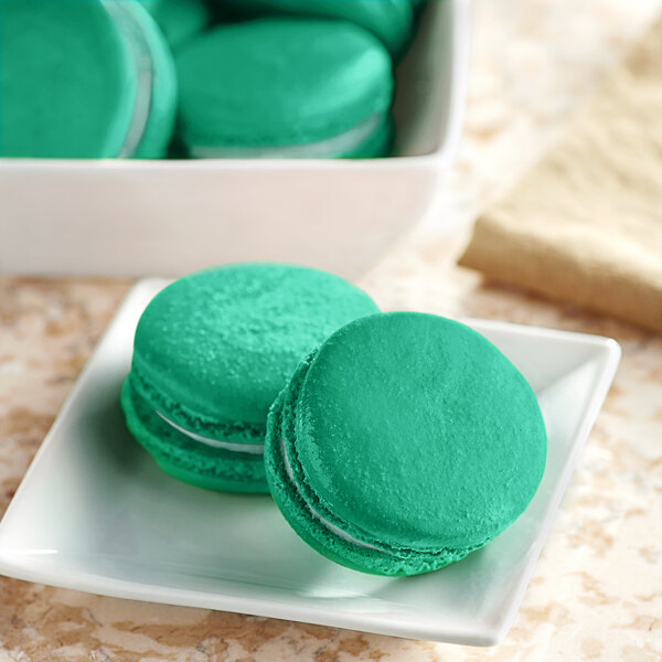 A white plate with green Chefmaster macarons.