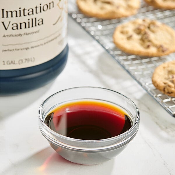 A glass bowl of Hometown Provisions Imitation Vanilla next to cookies.