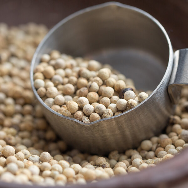 A bowl of Regal Whole White Peppercorns.