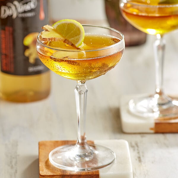 Two glasses of DaVinci Gourmet Spicy Ginger cocktails with lemon slices on top.