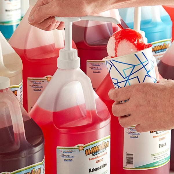 A person pouring Hawaiian Shaved Ice Bahama Mama syrup into a cup.