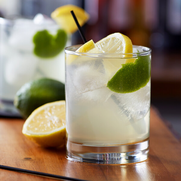 A glass of liquid with ice and lemon slices.