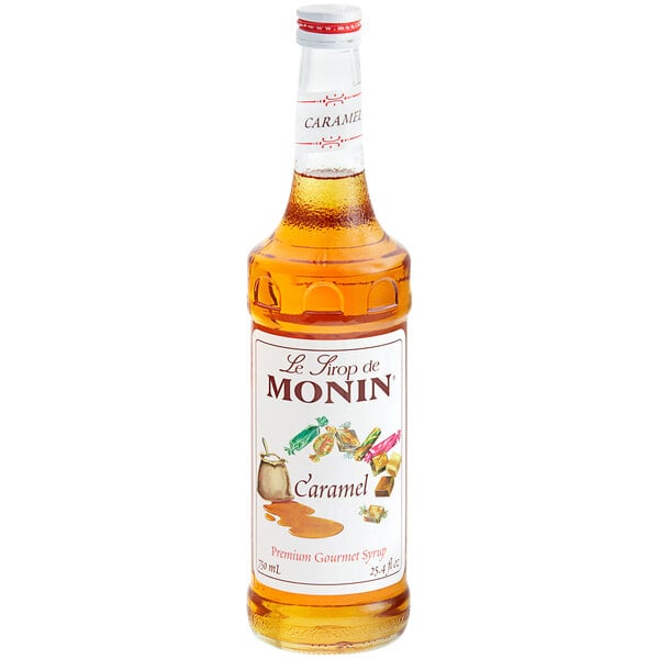 A bottle of Monin caramel syrup with a white label.