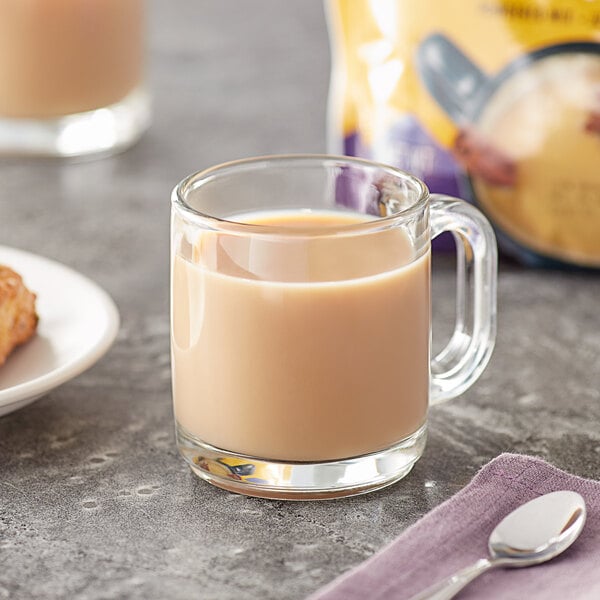 A glass mug of Oregon Chai tea latte with a spoon.