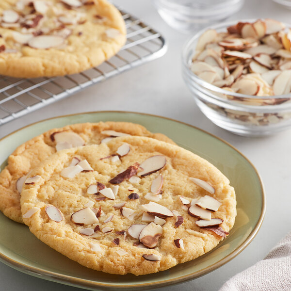 A plate of Nielsen-Massey almond butter cookies with sliced almonds on top.