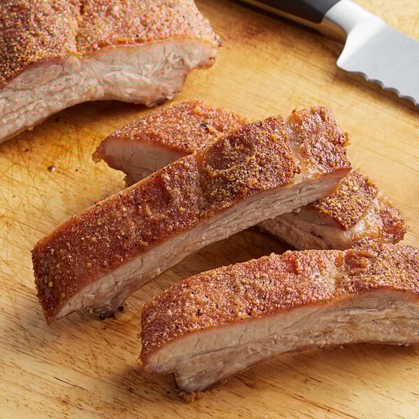 A piece of meat with Regal Sweet Meat Rib Rub on a cutting board.