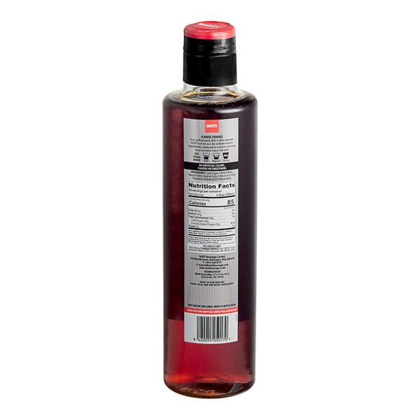A close-up of a SHOTT Flamed Orange flavoring syrup bottle with red liquid and a label.