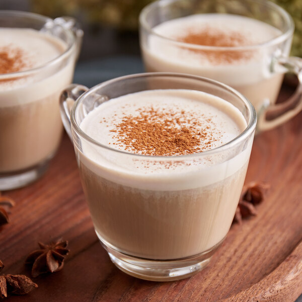 A group of glass cups of coffee with a sprinkle of Regal Pumpkin Pie Spice on top.