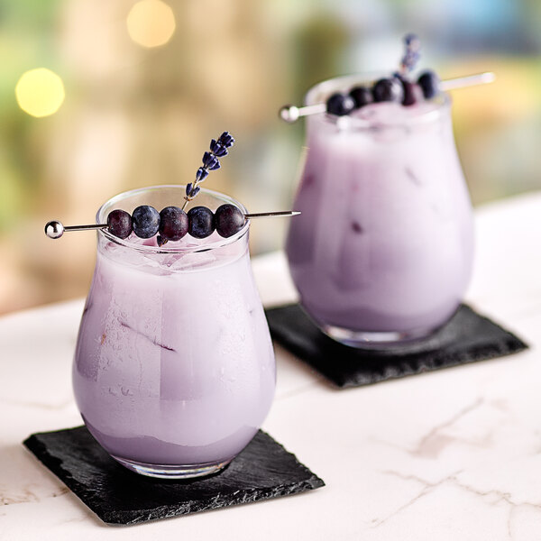 Two glasses of Fanale lavender syrup smoothie with blueberries on top.